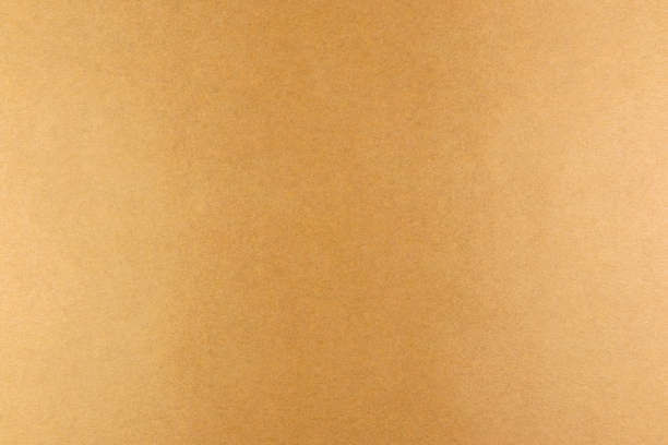 istock Brown background of real colored paper, illuminated by a soft light on the sides. 1253340163