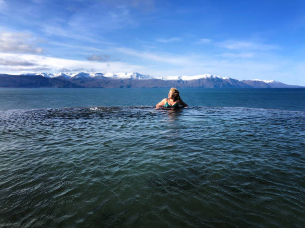 istock Active Senior in Iceland Hot Spring, Snowcapped Mountains 1253340175