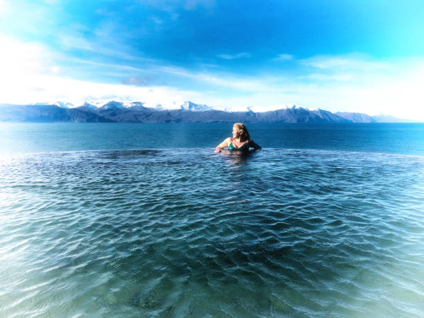 istock Active Senior in Iceland Hot Spring, Snowcapped Mountains 1253340264