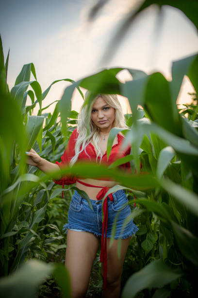 istock Beautiful woman is standing in corn field 1253340447