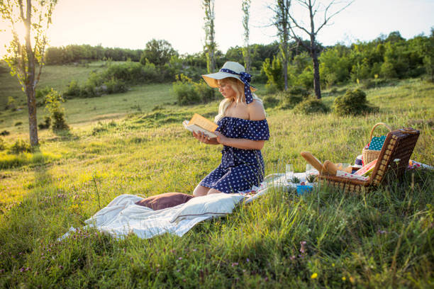 istock Beautiful woman reading in nature 1253340477