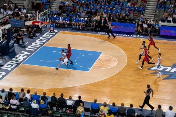 Basketball players tackling for ball