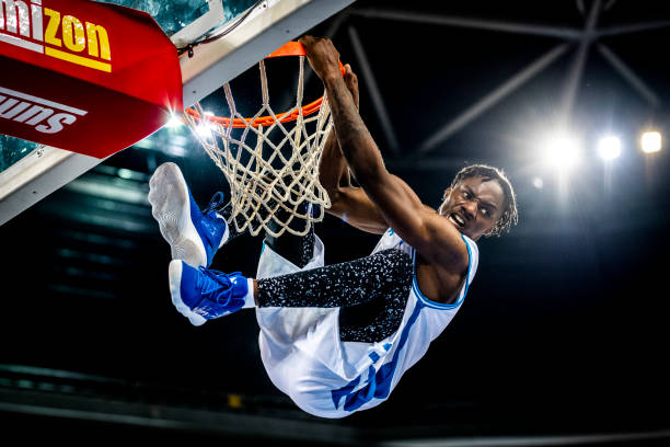 istock Basketball player hanging on hoop 1253343030