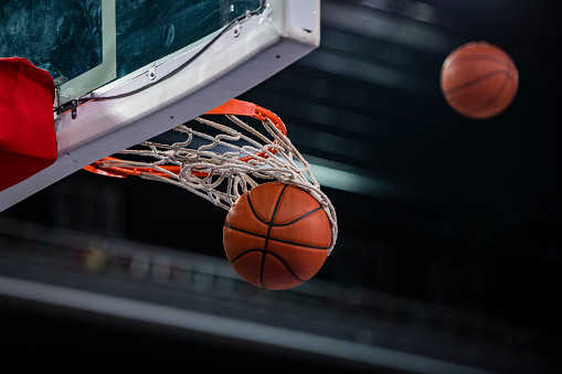 Close-up of basketball in hoop.