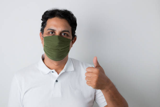 istock man with face protection mask making thumbs up with hands 1253347156