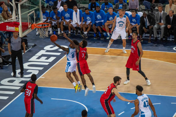 istock Basketball player slam dunking ball 1253347209