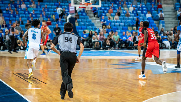 istock Basketball players playing on court 1253347354