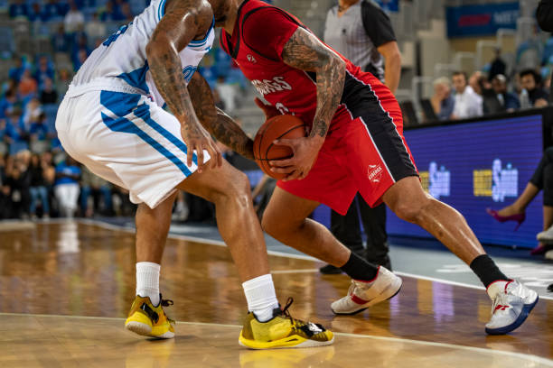 istock Basketball players tackling for ball 1253348176