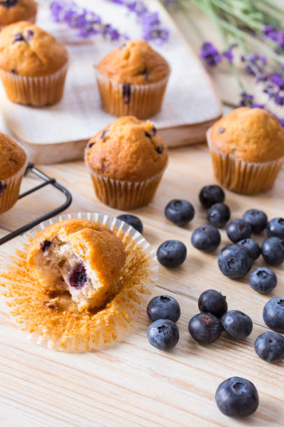 istock Blueberries muffins or cupcakes with fresh berries and lavender on wooden table. Summer colours and flavours 1253348314