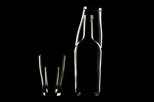 bottle and stacks empty without content on a dark background are highlighted along the contour. glass products abstraction