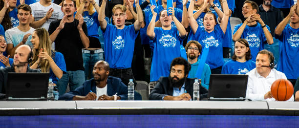 istock Spectators and commentators watching basketball match 1253349384