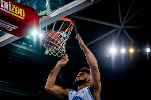 istock Basketball player slam dunking ball 1253349493