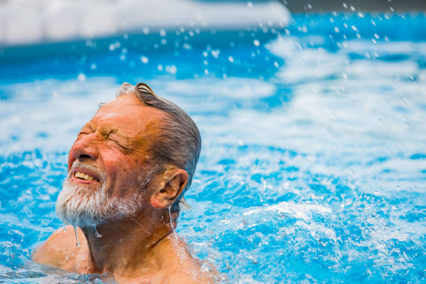 istock Senior man laughing in the pool 1253350087