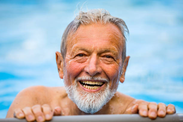 istock Senior man laughing in the pool 1253350169