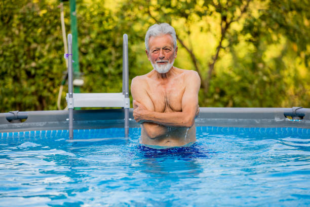 istock Senior man laughing in the pool 1253350325