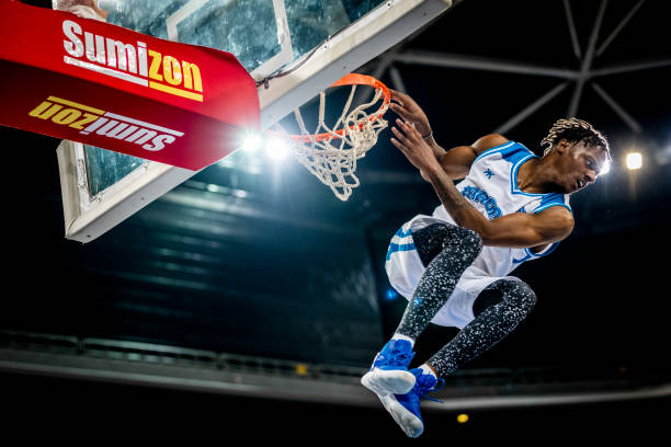 istock Basketball player hanging on hoop 1253350432