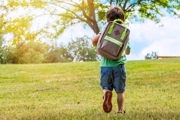 niño llevando una mochila caminando de regreso a la escuela - little boys preschooler back to school backpack fotografías e imágenes de stock