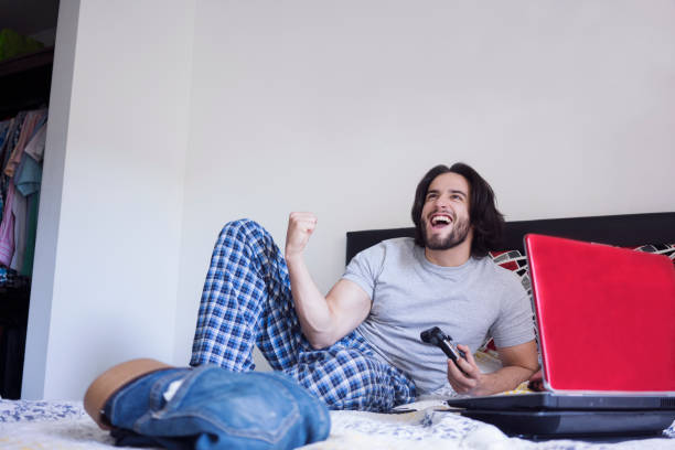 istock Latin ethnic man playing play in bed during Covid 19 1253353812