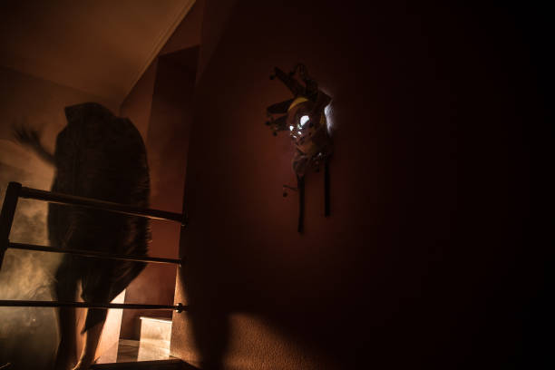 istock Horror concept. Scary mask with light on the wall inside dark room. Selective focus 1253353894