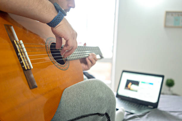 istock Latin ethnic man learning to play the guitar during Covid 19 1253355617