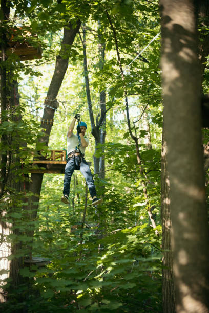 istock A man having a rope adventure in the forest with full insurance - sliding down using his rope belt 1253357386