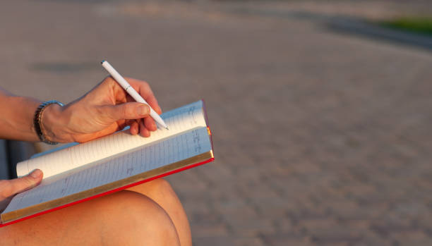 istock close up woman hand with pen writing on calender for note or make appointment concept. 1253358030