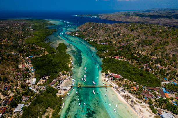 좁은 바다 채널을 통해 두 개의 열대 섬을 연결하는 다리의 공중 보기 (누사 렘봉간과 누사 세닝간, 인도네시아) - nusa lembongan 뉴스 사진 이미지