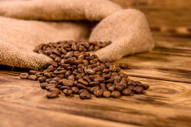 istock Sackcloth and scattered coffee beans on wooden table 1253361822