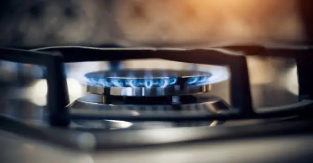 Kitchen modern gas cooker with burning fire propane gas. Gas stove. Blue flames on gas stove burner at home.