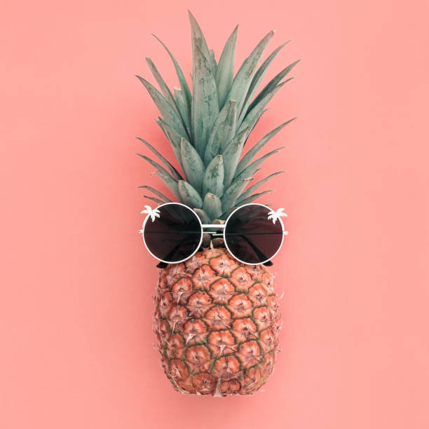 istock Pineapple fruit in sunglasses on pink pastel background 1253365692
