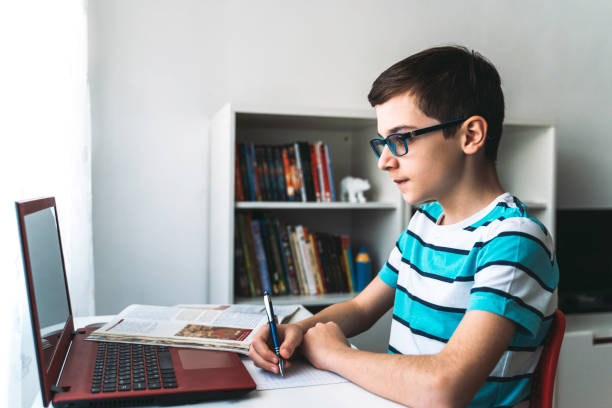istock Cute boy studying at home. Online education. Coronavirus epidemic 1253371271