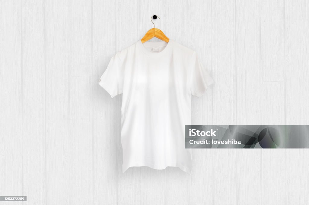 白い木の壁に掛けられた白いTシャツ - Tシャツのロイヤリティフリーストックフォト