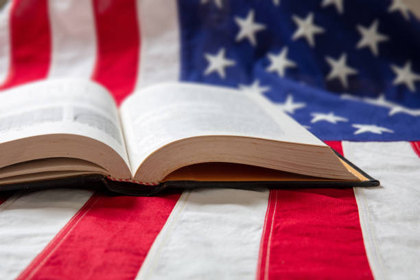 istock Open book on USA flag background, close up view. 1253373661