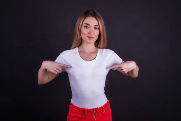 istock The smiling girl points at her t-shirt. 1253373882