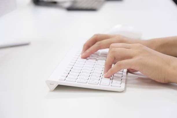 una donna giapponese che gestisce un computer nel suo ufficio - women typing human hand computer key foto e immagini stock