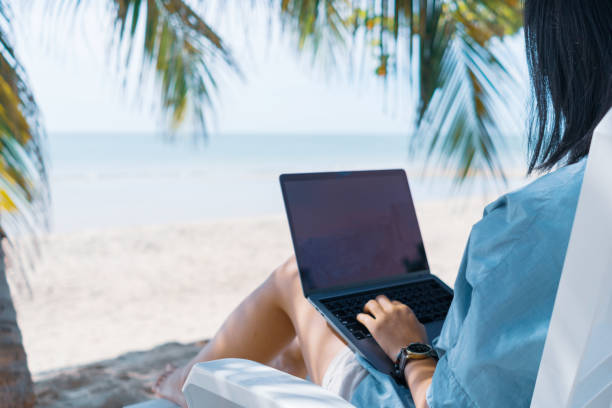 woman using laptop and smartphone to work study in vacation cady at beach background. business, financial, trade stock maket and social network concept. - on beach laptop working imagens e fotografias de stock