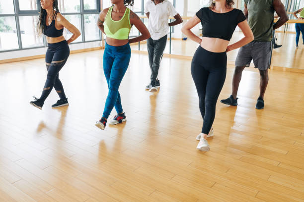 People dancing in class Smiling dancers keeping hands behind back and putting one leg forward when dancing in class dancing school stock pictures, royalty-free photos & images