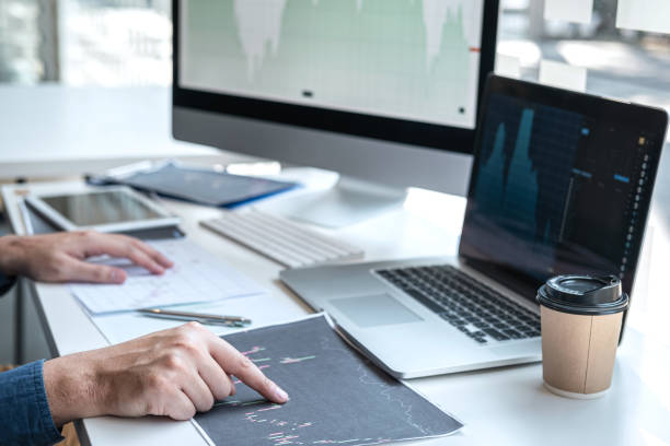 istock Stock exchange market concept, stock broker looking at graph working and analyzing with display screen, pointing on the data presented and deal on a exchange, Businessman trading stocks online 1253381371