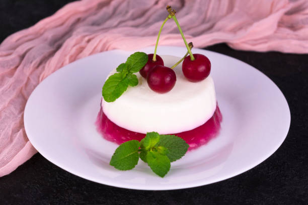 istock Panakota with cherry jelly and mint on a black background. 1253383996