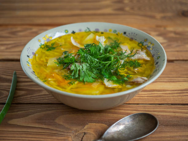 istock Closeup chicken soup sprinkled with chopped onion feathers in a deep ceramic plate. 1253384797
