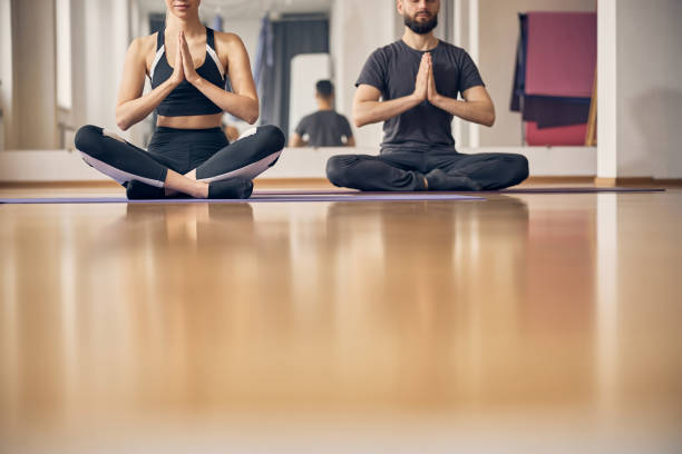 istock Man and a woman meditating in a lotus pose 1253387470