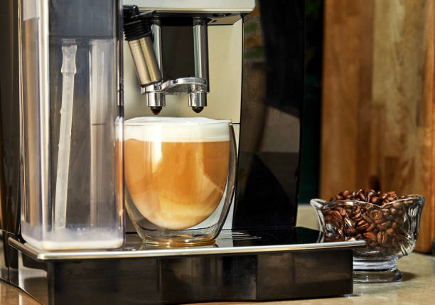 istock Coffee machine makes cappuccino coffee in a transparent cup 1253389212