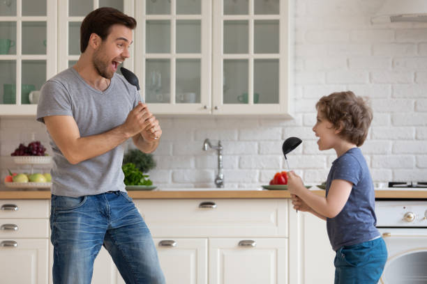 istock Happy dad and small son have fun singing at home 1253390195