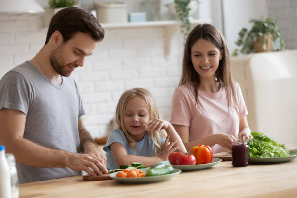 istock Happy young parents cooking together with small daughter 1253390202
