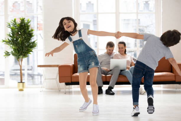 istock Happy brother and sister holding hands and spin 1253390274