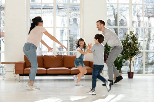 istock Blindfolded mother and father with children playing hide and seek. 1253390301