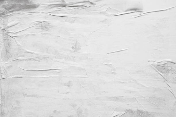 istock Blank white crumpled and creased paper poster texture background 1253390385