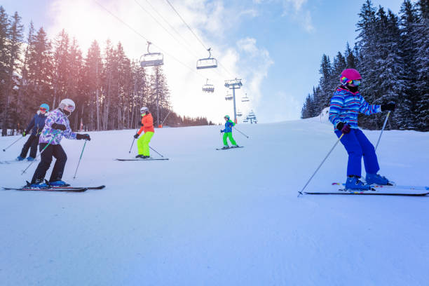 istock Children do mountain ski in school row formation 1253390584
