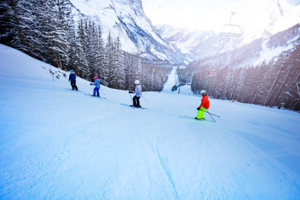 istock Kids mountain ski down slope in school formation 1253390679