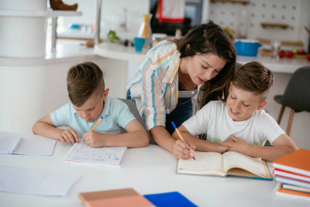 istock Mother helping children with they homework. 1253394588